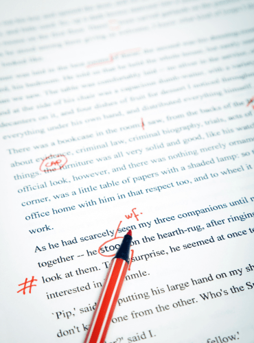 English text with errors highlighted in red. A red pen is visible.